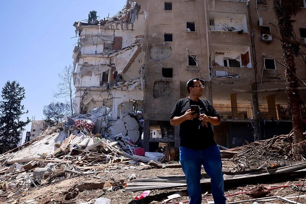 A resident checks the destruction following an overnight Iranian missile strike in Rohobot